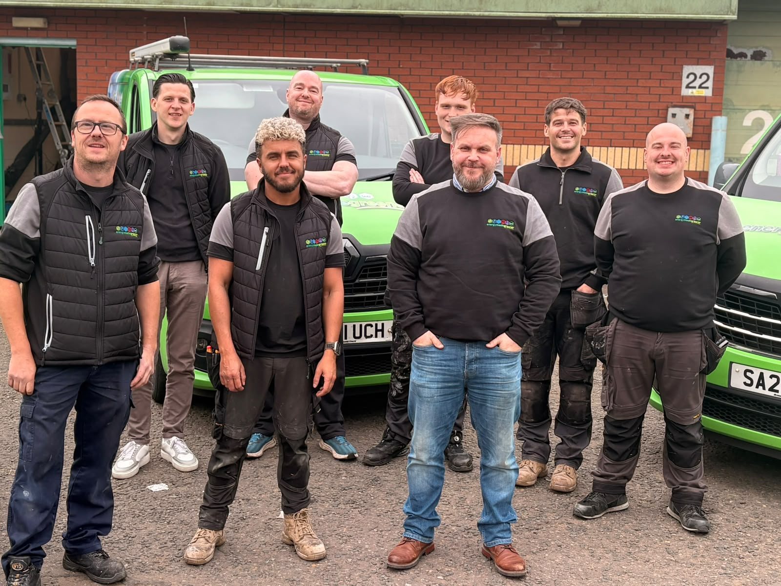 The Energy Made Greener team of heating and renewable-energy engineers with their branded vans at the EMG unit in Glasgow